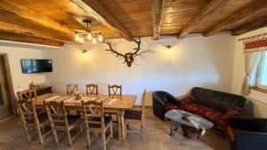 a dining room with a table and a couch at Casa de sub Horă in Zărneşti