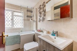 a white bathroom with a sink and a toilet at Rest & Nest in Chelsfield
