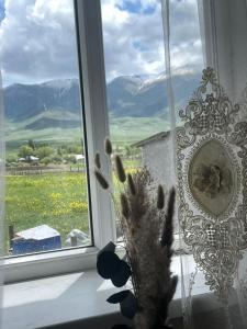 a window with a vase with a plant in front of it at Nomad place - horse riding tour Son-Kul in Dzhangyaryk
