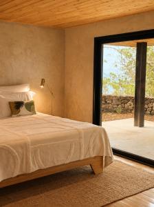 ein Schlafzimmer mit einem Bett und einem großen Fenster in der Unterkunft Aromas Studio in Terra Alta