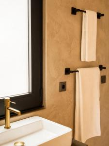 ein Badezimmer mit einem weißen Waschbecken und einem Fenster in der Unterkunft Aromas Studio in Terra Alta