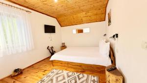 a small bedroom with a bed and a window at Casa de sub Horă in Zărneşti