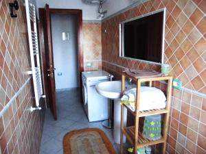 La petite salle de bains est pourvue d'un lavabo et d'un miroir. dans l'établissement Casa vacanze Villa Lucheria Loceri, à Loceri