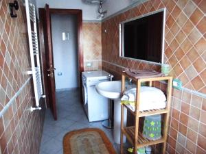 un piccolo bagno con lavandino e specchio di Casa vacanze Villa Lucheria Loceri a Loceri