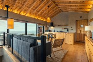 a kitchen and dining room with a view of the ocean at Casa da Figueira in São Roque do Pico