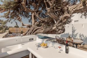 a kitchen with a tree on the roof of a house at Ammolofos Luxury Apartment & suites in Naxos Chora