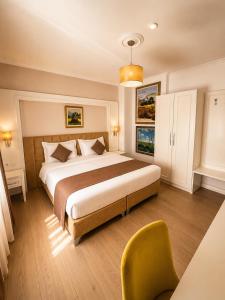 a bedroom with a large bed and a chair at ART Hotel Tirana in Tirana +26 photos