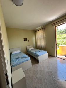 two beds in a room with a window at Rigandi in Durrës