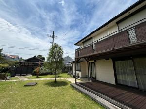 a house with a yard with a tree next to it at Sakai Garden and Villa in Sakai