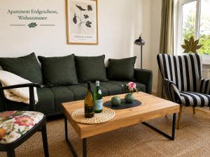 a living room with a green couch and a table at Villa Deli in Wischhafen