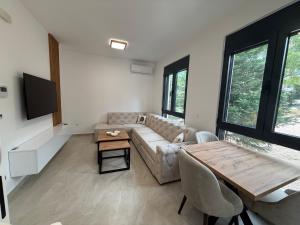 a living room with a couch and a table at Sea Sand Apartment in Bijela Glavica