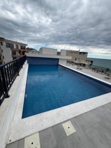 a swimming pool on top of a building with the ocean at Sea Sand Apartment in Bijela Glavica