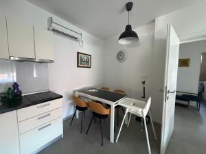 a kitchen with a table and chairs in a room at Apartman "WALKOW", SELF CHECK IN, FREE PARKING in Vukovar