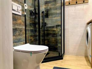 a bathroom with a toilet and a shower at Apartament Amelia in Zamość +37 photos