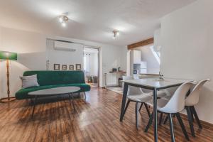 a living room with a green couch and a table at Orličky Apartments in Orličky