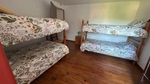 two bunk beds in a room with a wooden floor at Gaia Merindades in Salinas de Rosío