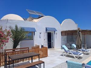 a patio with chairs and a table and a house at Maison Amina Villa Novel in Triffa