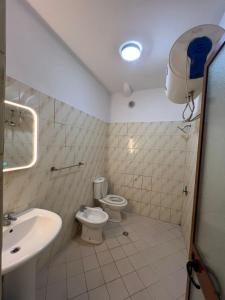 a bathroom with a toilet and a sink at Rigandi in Durrës +18 photos