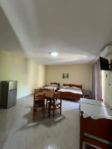 a room with two beds and a table and a television at Rigandi in Durrës