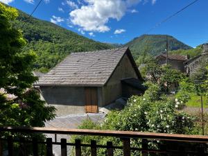 a small building with a roof with mountains in the background at Mountain house Junac in Lapège