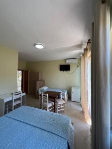 a bedroom with a bed and a table and chairs at Rigandi in Durrës