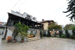 a house with stairs and plants in front of it at Pensiunea Antique in Târgu Jiu