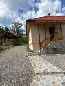 a building with a porch and a stone walkway at Casa dintre munti in Bozioru