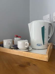 two large coffee pots sitting on a wooden shelf at Kilian's Lodge Hotel in Mullagh