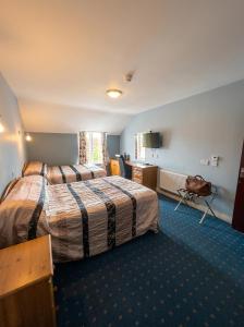 a hotel room with two beds and a kitchen at Kilian's Lodge Hotel in Mullagh