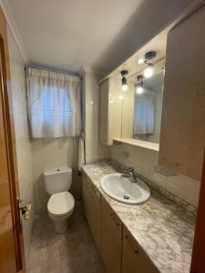 a bathroom with a sink and a toilet and a mirror at Casa Diego in Muñón Fondero