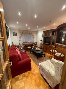 a living room with a red couch and a table at Casa Diego in Muñón Fondero