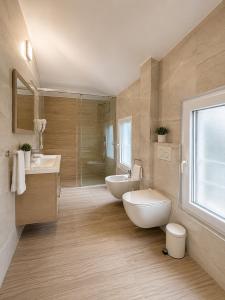 a bathroom with two sinks and a tub and a toilet at ART Hotel Tirana in Tirana