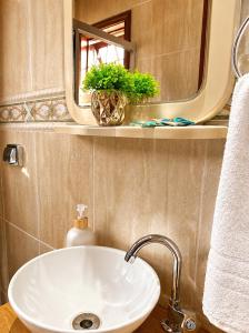 a bathroom with a sink and a mirror at Flats Morada do Jordão in Campos do Jordão +44 photos