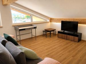 a living room with a couch and a flat screen tv at Hafenapartments Segelschule Mondsee in Mondsee