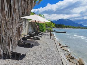 a row of chairs and an umbrella on the beach at Lana Seafront Apartments in Šušanj