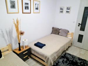 a bedroom with a bed and a table with a vase at Apartament Amelia in Zamość