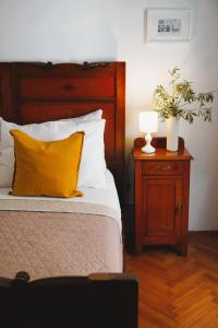 a bed with a yellow pillow and a night stand with a lamp at TT Apartmani - Historic Center Pula in Pula