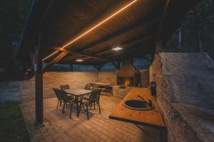 a patio with a table and chairs and a fireplace at Orličky Apartments in Orličky