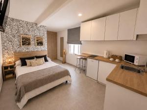 a bedroom with a large bed and a kitchen at Hostal Casa Miguel Marbella in Marbella