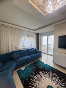 a living room with a blue couch and a flat screen tv at Das gemütliche Unterkunft in Gelsenkirchen