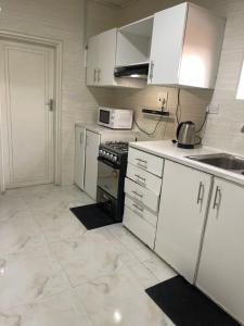 a kitchen with white cabinets and a stove top oven at Elimisam stays in Kitwe