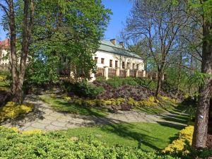 a large white house with trees and a garden at Apartament u Basi in Sanok