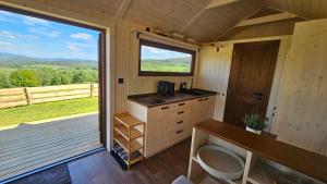 a kitchen with a sink and a large window at Glamping Šumava in Hartmanice