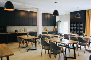 a restaurant with wooden tables and chairs and a kitchen at La Park Aparthotel in Kudowa-Zdrój