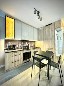 a kitchen with a table and two chairs and a counter at InGalaxy Green Apartment in Szczecin