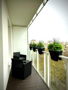 a balcony with chairs and potted plants on it at InGalaxy Green Apartment in Szczecin