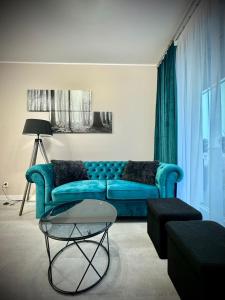 a living room with a blue couch and a table at InGalaxy Green Apartment in Szczecin