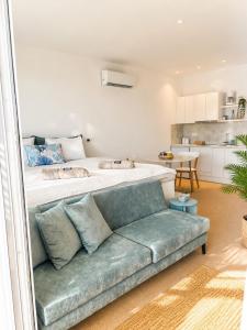 a bedroom with a large bed and a couch at Almyra Suites in Archangelos
