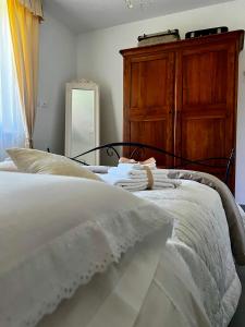 a bedroom with a white bed with a wooden dresser at Il Refolo in Norcia