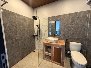 a bathroom with a toilet and a sink and a shower at Tera Bali Villa 3 Bedugul in Bedugul +3 photos